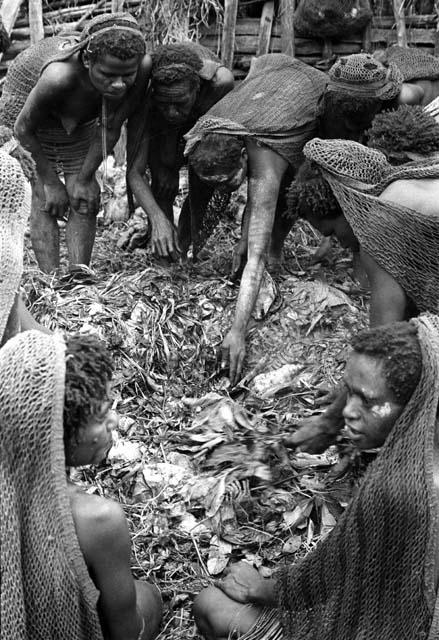 Men working in hakse; taking out some potatoes