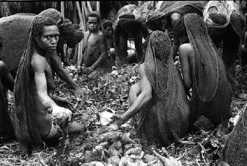 Men working in hakse; taking out some potatoes