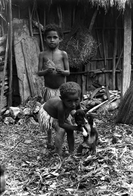 2 children with a small puppy; Nameliké is one of the girls