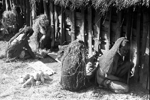 Women huddled against the side of the hunu at Abulupak the day after the funeral for Weaké