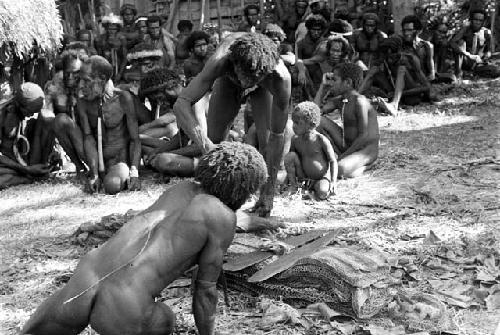 Men arranging yes and sus near the honai at Abulupak; Haliole's sili