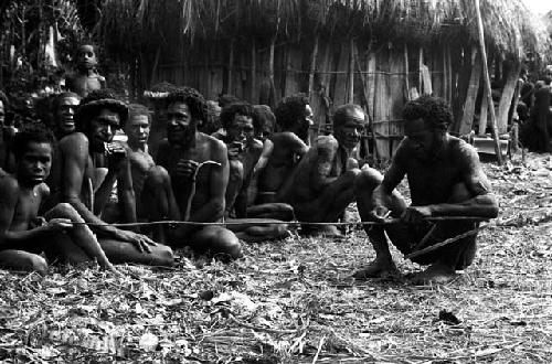 Etamugwi making a bow; making a string; Natuwanike in the frame