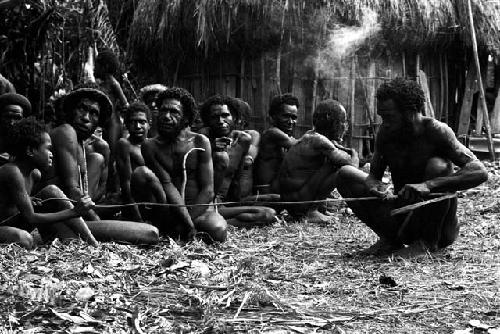 Etamugwi making a bow; making a string; Natuwanike in the frame