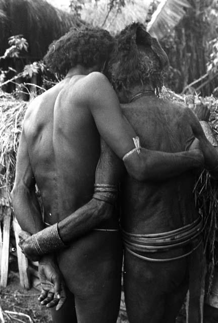 Two men greet each other in mourning