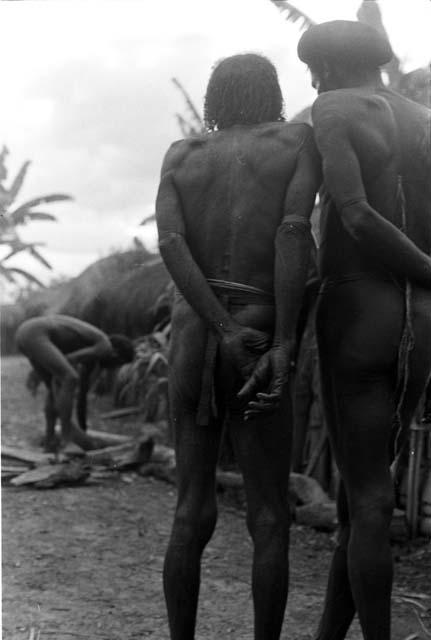 2 men talk; seen from the back in the sili of Haliole