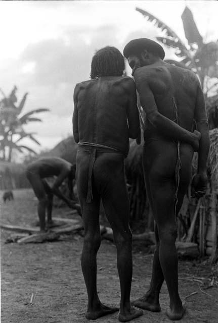 2 men talk; seen from the back in the sili of Haliole