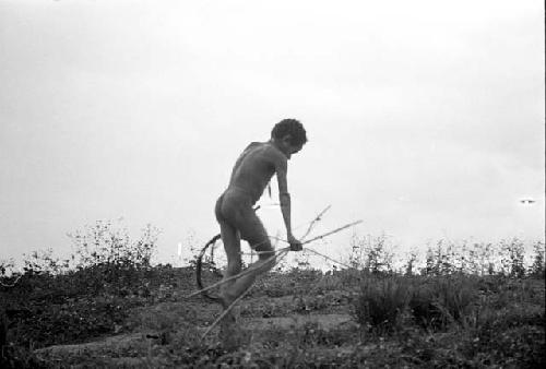 Uwar with spears in his right hand; hoop in his left hand