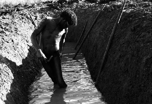 A man washing in the ditch after a day's labor