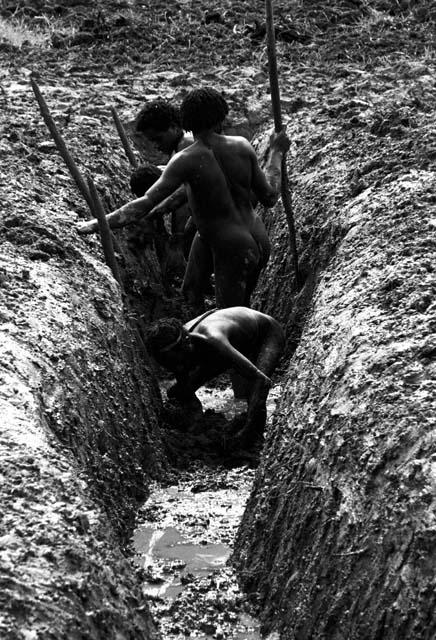 Men clearing a ditch