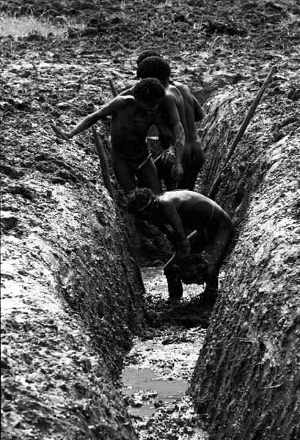 Men clearing a ditch