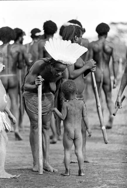 Woman talking to a child; people behind her dancing