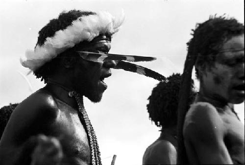 Man singing, women around him dancing