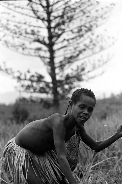 Girl playing sikoko wasin, about to spear a hoop