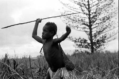 Girl playing sikoko wasin; she watches the hoop from in front