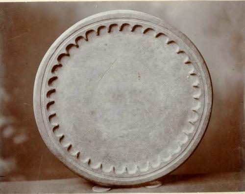 Round stone disc, with wave-like decorations