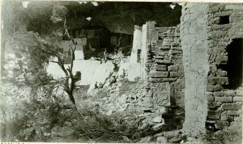 View of ruins of Cliff Palace, from distance, six men (and women?) in background