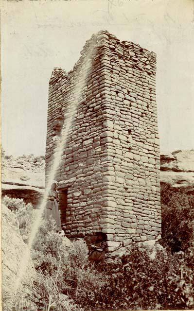 Ruins, rectangular building of brick-shaped stones, features two women