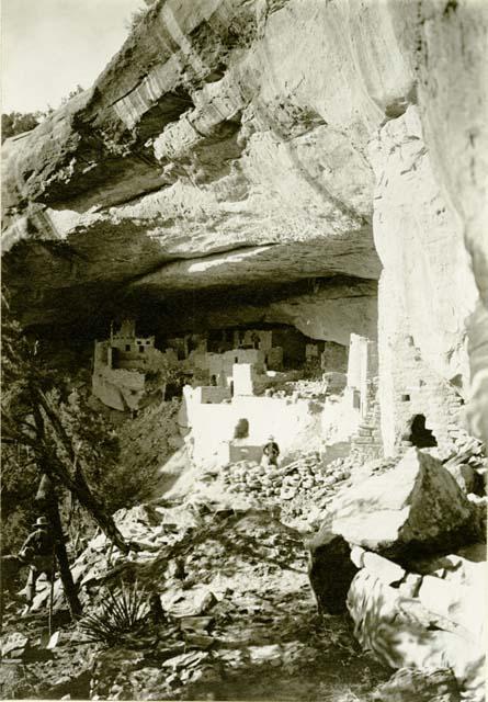 Cliff Palace ruins from South, two men in foreground and one man in background