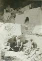 Men repairing a kiva in Cliff Palace, with Speaker Chief's house in background