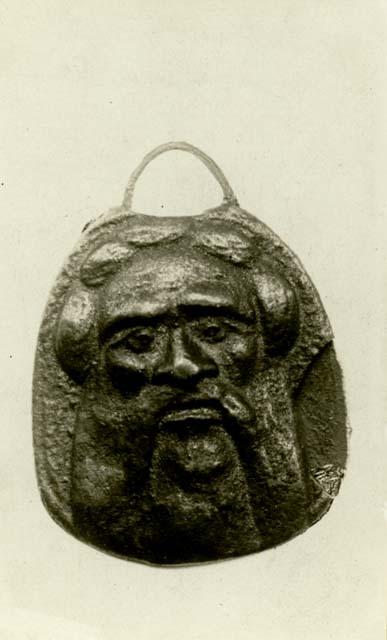 Small medallion with bearded face.