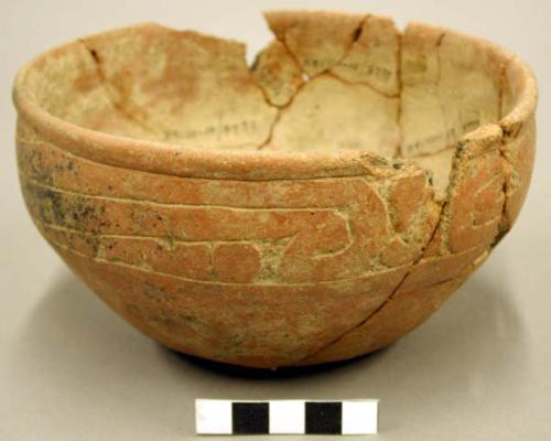 Ceramic bowl, mended, sherds missing, incised rim & body, red painted exterior.