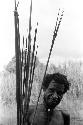 A man standing with a handful of arrows and a bow near Homoak