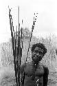 A man standing with a handful of arrows and a bow near Homoak