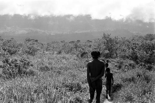 A man and some boys walking along a path