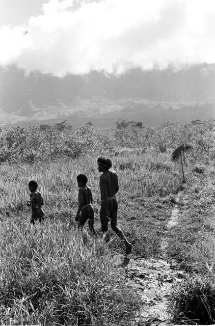 A man and some boys walking along a path