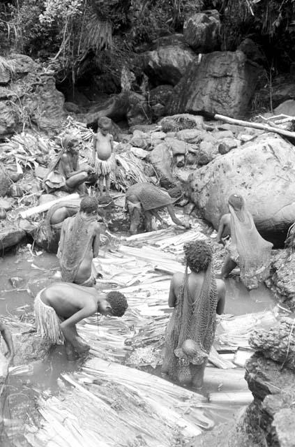 Women and children working in the salt pool at the salt well