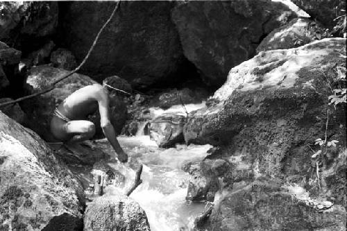 A man stops by the small creek that runs down the trail from the salt wells