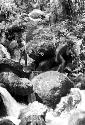 Man walking along the boulders in the stream bed