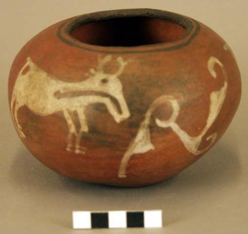 Hand made red pottery vase, almost spherical, with two white painted deers.