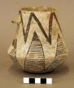 Ceramic pitcher, broken handle, brown on white exterior, depression in base