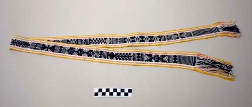 Woven belt in black, white, yellow and light pink with fringe; geometric pattern