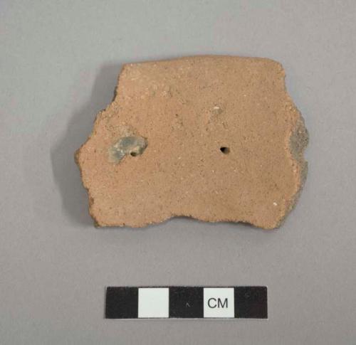 Perforated plate sherd. two perforations (plus one broken along edge) about 3.1 cm. from rim edge; a third perforation broken along edge; plainware.