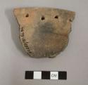 Perforated plate sherd with three perforations ca. 1.5 cm. from rim edge (4th evident along broken edge of sherd). brown ware.