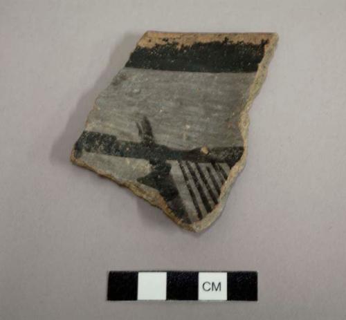 Rim sherd of a bowl, interior is decorated with a black on white linear and geometric design, exterior is slipped red - gila polychrome