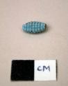 Glass bead, tubular with rounded ends, pale blue, textured surface, corn-shaped