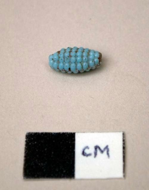 Glass bead, tubular with rounded ends, pale blue, textured surface, corn-shaped