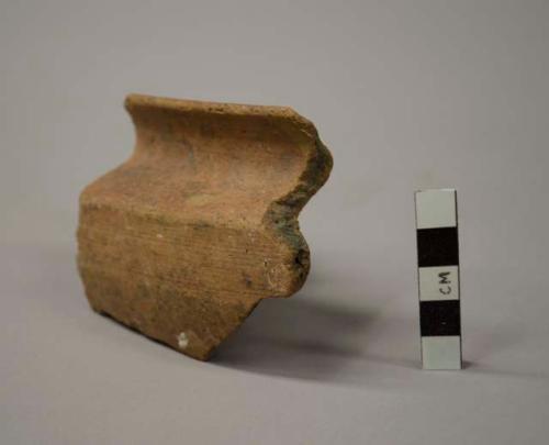 Sherd of  large spouted basin with recurved rim, coarse brown ware