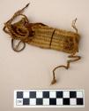 Woven fiber fragment with hide woven in, ties on both ends, possibly an ornament