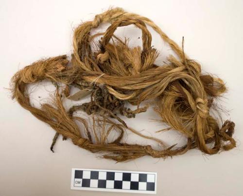 Long fiber fragments, plaited and knotted with twine and hide fragments