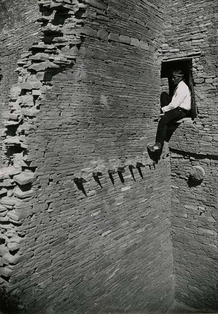 Indian man sitting in doorway at Pueblo Bonito