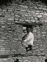 Indian man sitting in doorway at Pueblo Bonito