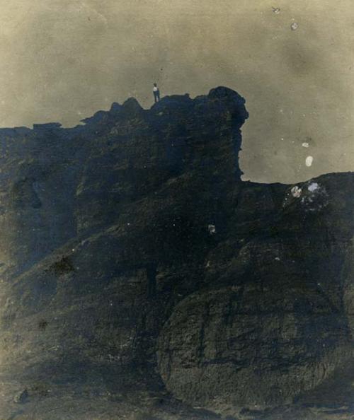 Man standing atop a large cliff