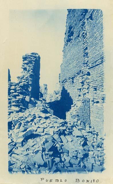 Inner view of Pueblo Bonito amongst piles of stone ruin.