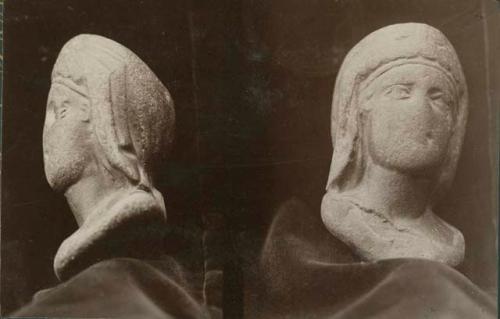 Sculpted stone head of woman wearing headpiece