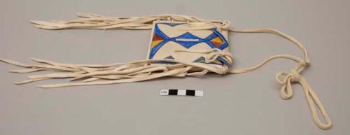 Small parfleche bag with painted design; rawhide strap; rawhide ties at top flap; long rawhide ties at each side