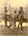 Photograph from New Queensland of three adults, two children, dog, walking